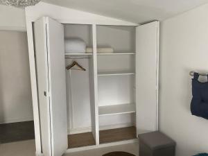 a white closet with white shelves in a room at T2 cyclamen independent in Cholet +17 photos