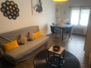 a living room with a couch and a table at T2 cyclamen independent in Cholet