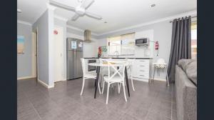 a kitchen and dining room with a table and chairs at Ocean Beach Chalet 18 in Jurien Bay