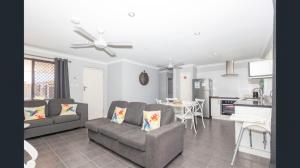 a living room with two couches and a kitchen at Ocean Beach Chalet 18 in Jurien Bay