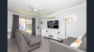 a living room with two couches and a tv at Ocean Beach Chalet 18 in Jurien Bay