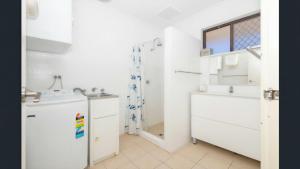 a white bathroom with a sink and a mirror at Ocean Beach Chalet 18 in Jurien Bay +14 photos
