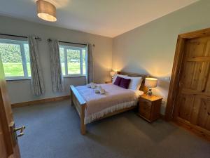 a bedroom with a bed with two lamps and two windows at Dingle Mist in Dingle
