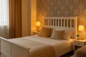 a bedroom with a large white bed with two lamps at AltstadtNest Hannover in Hannover +6 photos