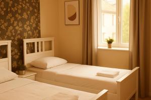 two beds in a small room with a window at AltstadtNest Hannover in Hannover