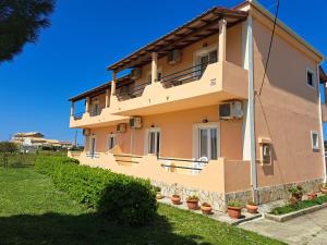 a building with potted plants in front of it at Feakes Apartments in Arillas