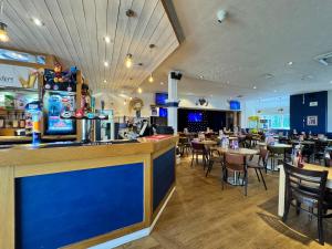 a restaurant with a bar and tables and chairs at Kieras View At Bideford Bay in Bideford