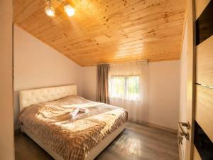 a bedroom with a bed with a wooden ceiling at Galaluxe in Tʼeghut