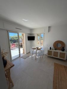 a living room with a table and chairs and a television at Villa U Mulinu in Calvi