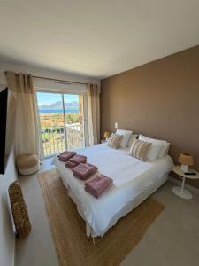 a bedroom with a large white bed and a window at Villa U Mulinu in Calvi +66 photos