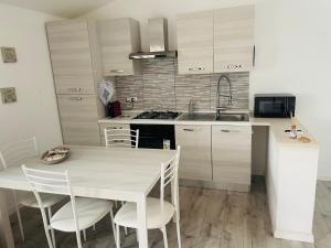 a kitchen with a table and chairs and a sink at Il Mirto, Residenza Privata in Bacu Abis