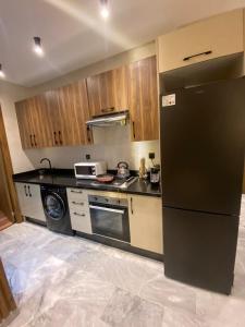 a kitchen with a black refrigerator and a dishwasher at studio neuf calme et propre in Casablanca +4 photos
