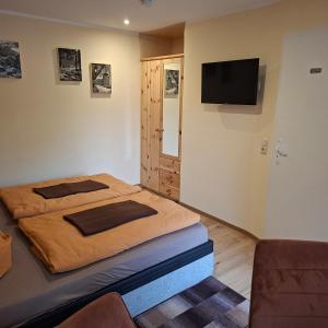 a bedroom with a bed and a flat screen tv at Pension Lehmann in Radebeul