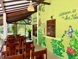 a restaurant with a green wall with a monkey mural at JungleRiverHouse & JungleRiverResort in Bukit Lawang