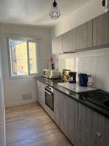 a kitchen with gray cabinets and a counter top at Appartement climatisé centre-Ville in Bastia