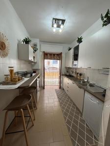 a kitchen with white cabinets and a sink and a counter at Chicca House in Maiori