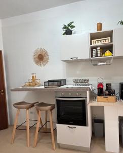 a kitchen with a counter with stools and a stove at Chicca House in Maiori +16 photos