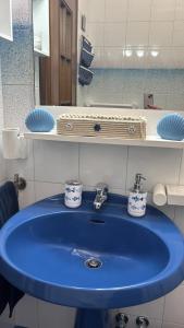 a blue sink in a bathroom with a mirror at Chicca House in Maiori