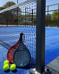 a tennis racket and tennis balls on a tennis court at bungalow le TXOKO in Lit-et-Mixe
