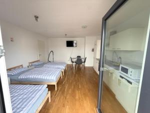 a room with three beds and a table in it at LuxApart2Cologne in Kerpen