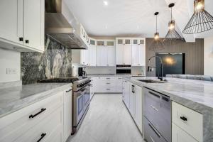 a kitchen with white cabinets and stainless steel appliances at Marbella Lane Coastal Elegance Villa with Pool in Cabo San Lucas