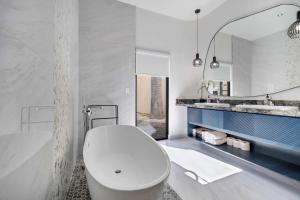 a bathroom with a white toilet and a sink at Marbella Lane Coastal Elegance Villa with Pool in Cabo San Lucas