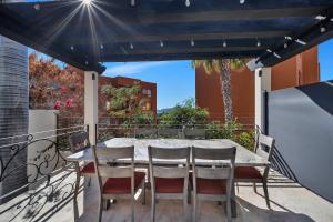 a table and chairs on a balcony with a view of a building at Marbella Lane Premium Ocean View Villa & Pool in Cabo San Lucas
