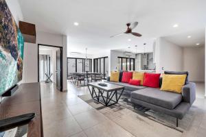 a living room with a couch with colorful pillows at Marbella Lane Premium Ocean View Villa & Pool in Cabo San Lucas