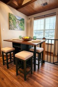 a kitchen with a table with stools and a bowl of fruit at Sunlit Loft, Near GSP and Private Entry in Greer