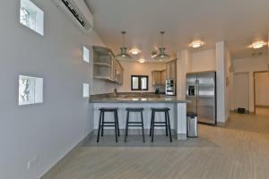 a kitchen with two bar stools and a counter top at Marbella lane - Stylish Private Villa OceanViews in Cabo San Lucas