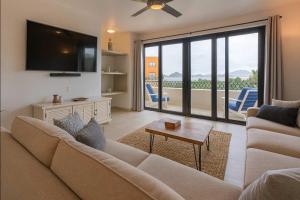 a living room with a couch and a flat screen tv at Marbella lane - Stylish Private Villa OceanViews in Cabo San Lucas
