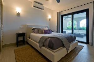 a bedroom with a bed and a large window at Marbella lane - Chic Casa with Amazing OceanViews in Cabo San Lucas