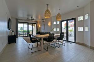 a dining room with a wooden table and chairs at Marbella lane - Chic Casa with Amazing OceanViews in Cabo San Lucas