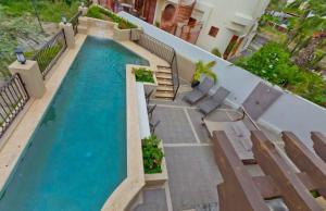 an overhead view of a swimming pool with chaise lounge chairs at Marbella lane - Chic Casa with Amazing OceanViews in Cabo San Lucas +39 photos