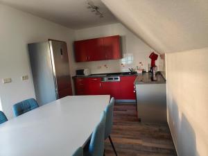 a kitchen with red cabinets and a table with chairs at Ferienwohnung Zentrum Luckau in Luckau