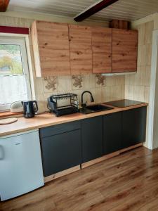a kitchen with wooden cabinets and a sink at Beskidzka Oaza in Targanice +17 photos