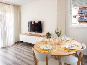 a dining room with a table with chairs and a tv at Fenals Calm - con piscina in Lloret de Mar
