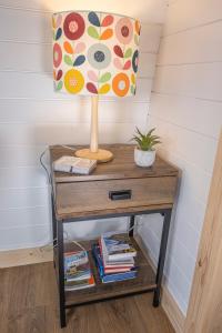 a table with a lamp and books on it at Appin's Coorie Nook in Appin