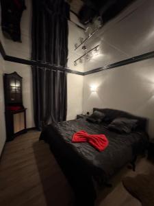 a bedroom with a bed with a red bow tie on it at maison romantique avec spa privé in Montargis