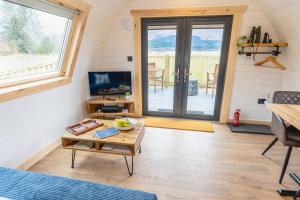 a living room with a table and a sliding glass door at Appin's Coorie Nook in Appin