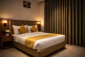 a bedroom with a large bed with yellow pillows at Hotel Rs Vista - Agra in Agra +22 photos