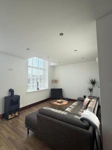 a living room with a couch and a tv at Hollins Mill Apartment in Sowerby Bridge