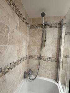 a bath tub with a shower in a bathroom at Hollins Mill Apartment in Sowerby Bridge +27 photos