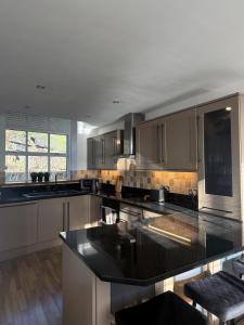 a large kitchen with a large black counter top at Hollins Mill Apartment in Sowerby Bridge
