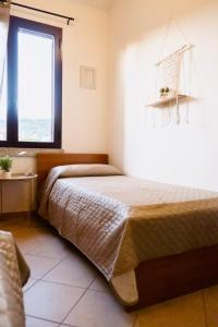 a bedroom with a bed and a window at ALMA'RE Le Trame di KaSa Experience in Porto Ottiolu +27 photos
