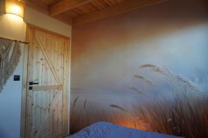 a bedroom with a bed and a wall with tall grass at Stodoła Pod Gwiazdami - Jezioro Głuszyńskie in Orle +31 photos