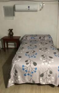 a bed with a white blanket with blue flowers on it at Iberá in Mercedes