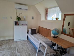 a bedroom with a bed and a desk and a window at Céhmesterek apartman in Eger