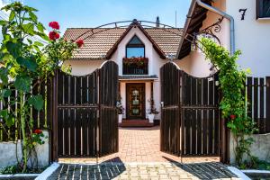 a gate to a house with flowers on it at Panorama Guesthouse in Sighişoara +19 photos