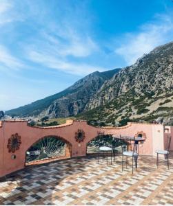 a patio with a table and chairs in front of a mountain at Haven Hills Chaouen in Chefchaouen